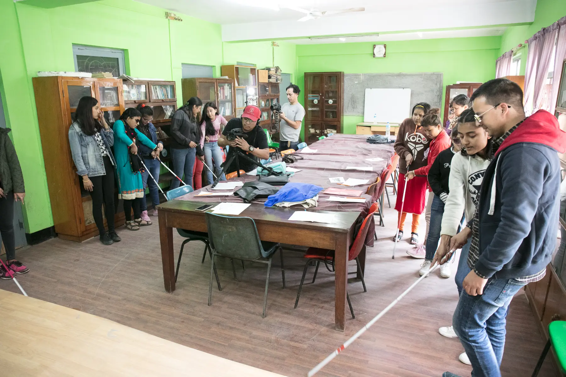 Participants with visual disabilities are receiving guidance in learning about the mobility techniques from their pairs.