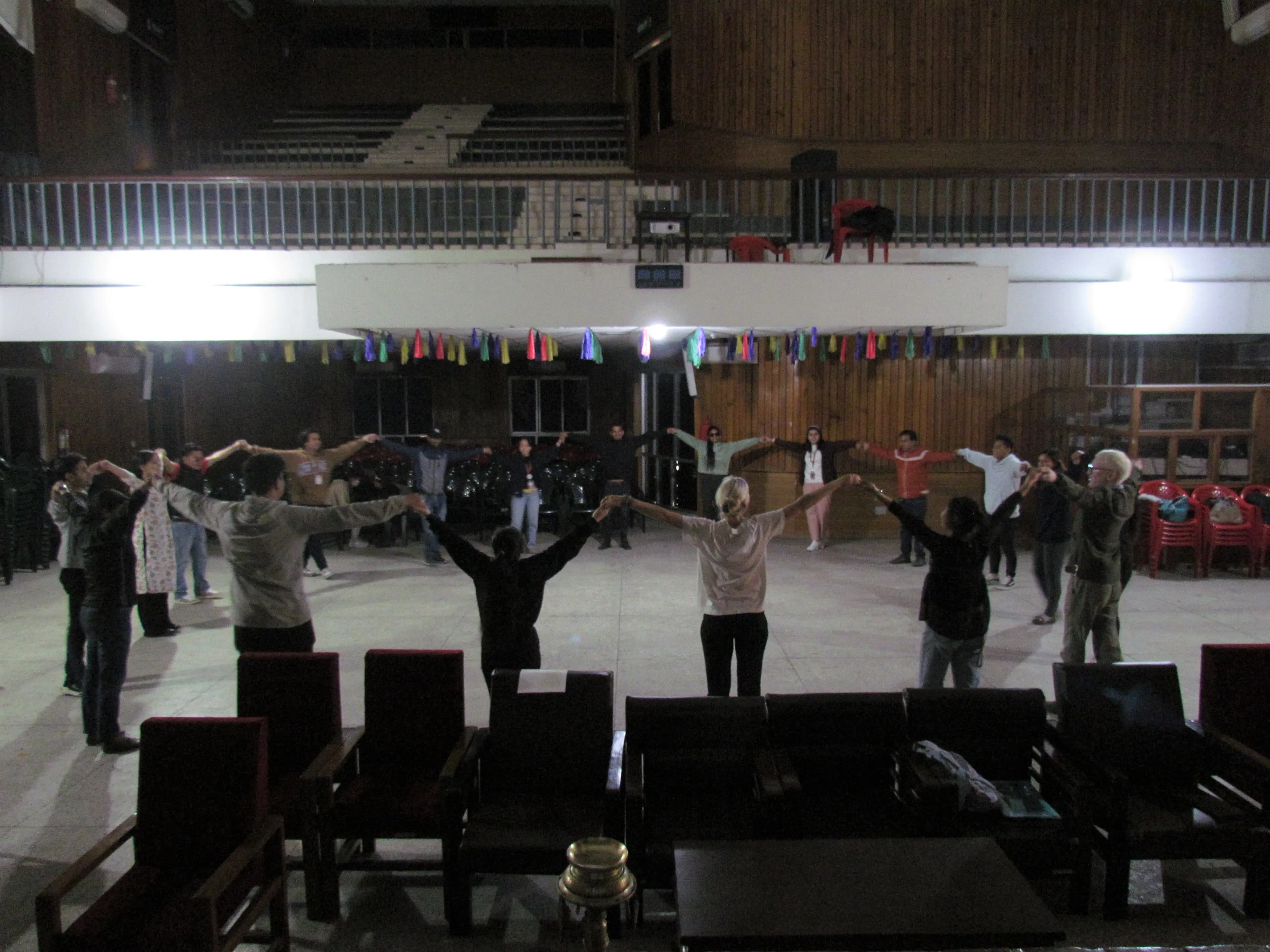 All the participants are holding each others hands and making a big circle.