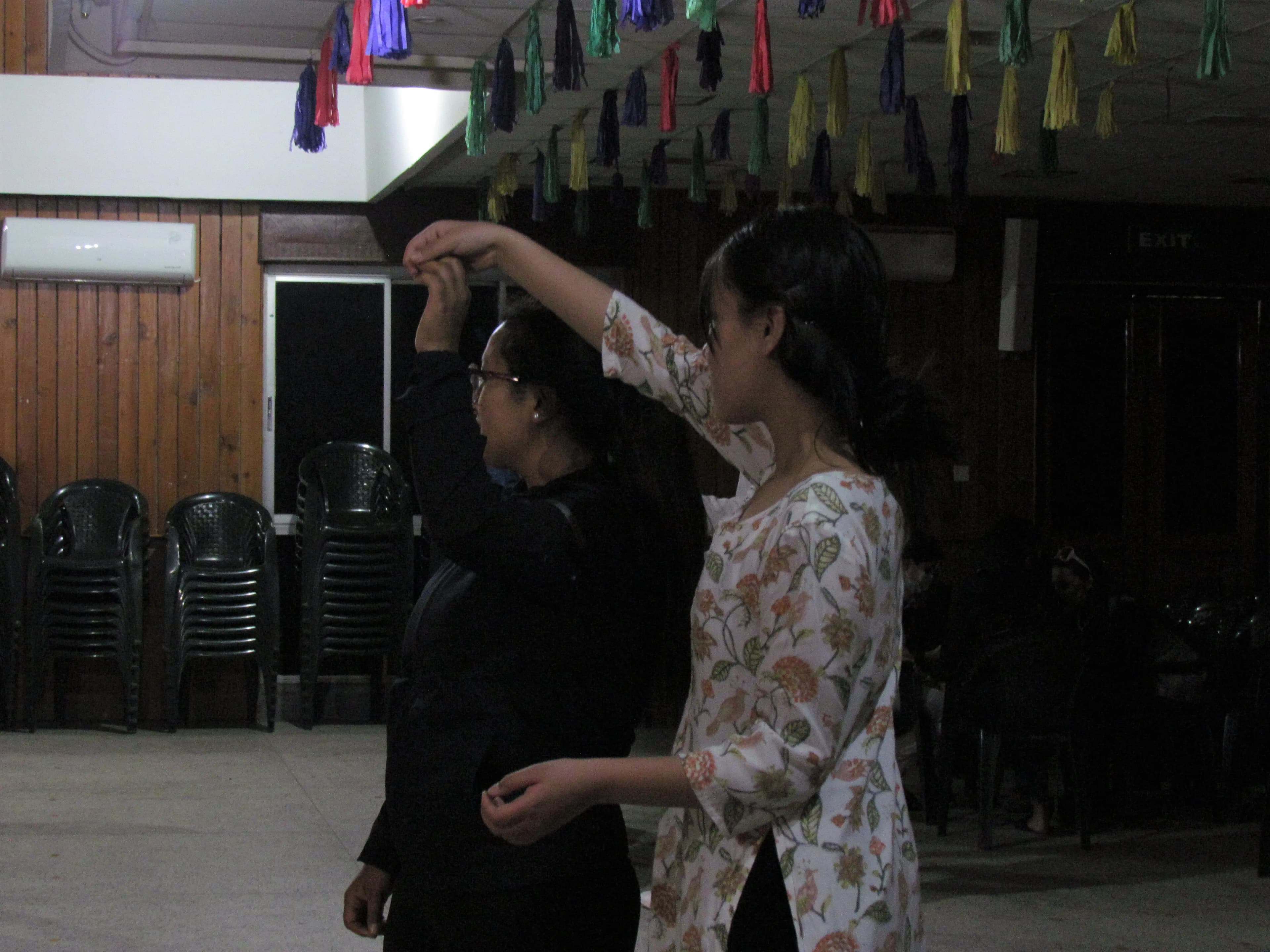 One of the dancers with visual disabilities is being guided by her partner to learn a dance step.
