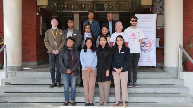 A group picture of all the members of partners representing different organization present in the meeting along with the banner of Chain For Change.