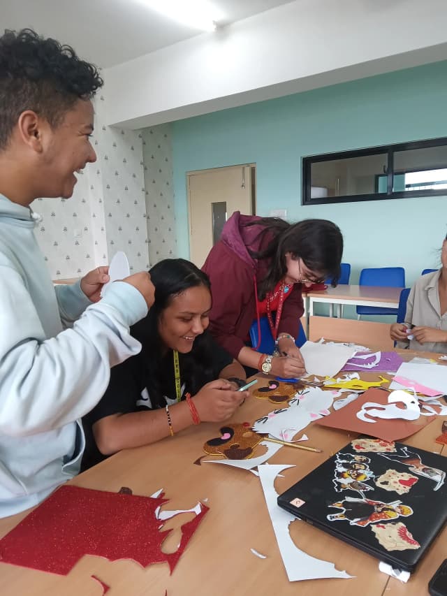 A picture where one of the design team is drawing an outline. In the background fellow designers are observed smiling.