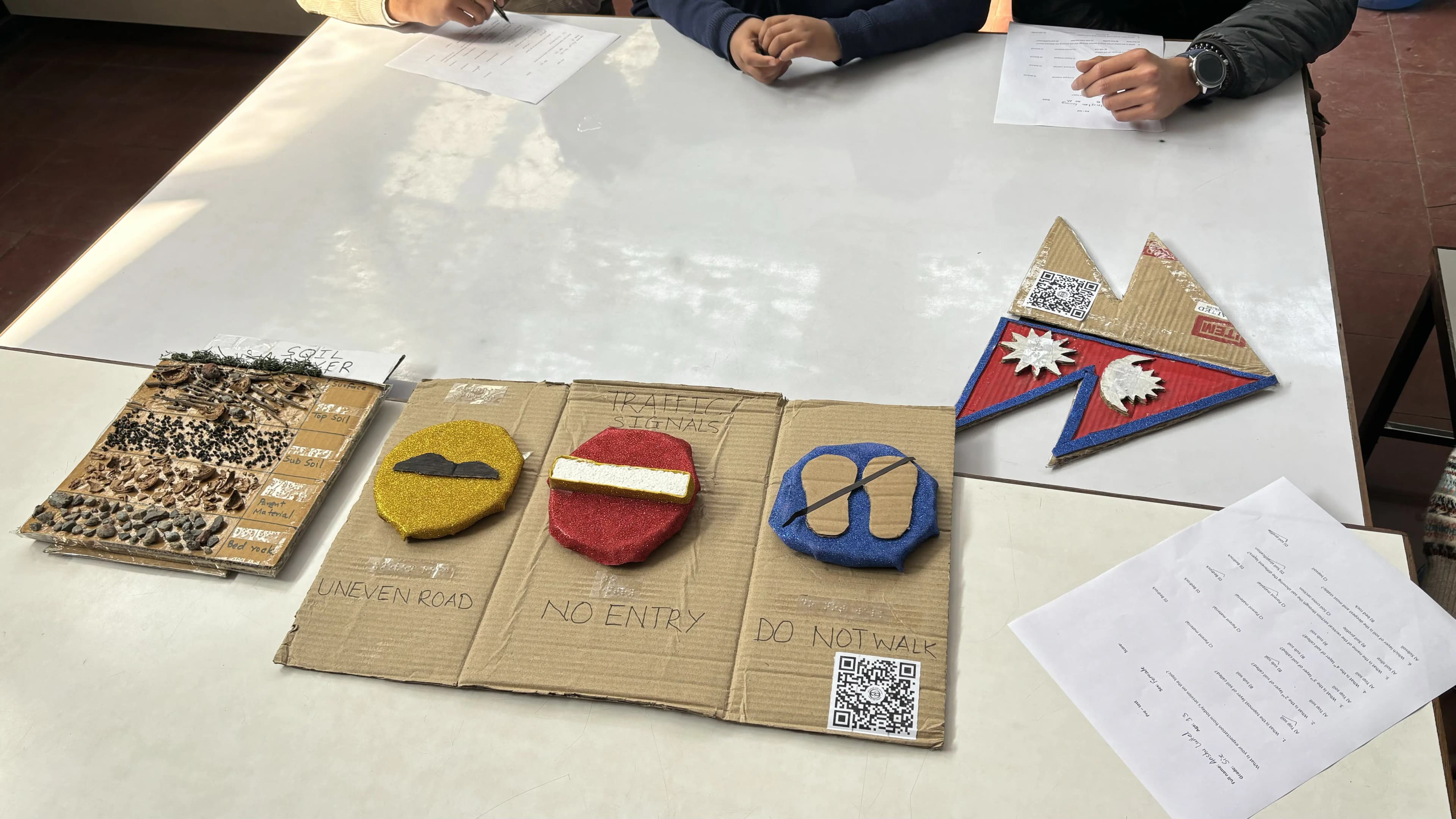 A picture of 3 3D models of the workshop where 3D model of Soil Layers is placed on left, traffic Signs in middle and Flag of Nepal on the right.