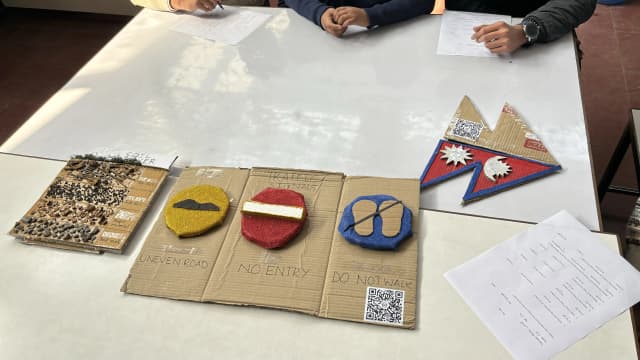 A picture of 3 3D models of the workshop where 3D model of Soil Layers is placed on left, traffic Signs in middle and Flag of Nepal on the right.