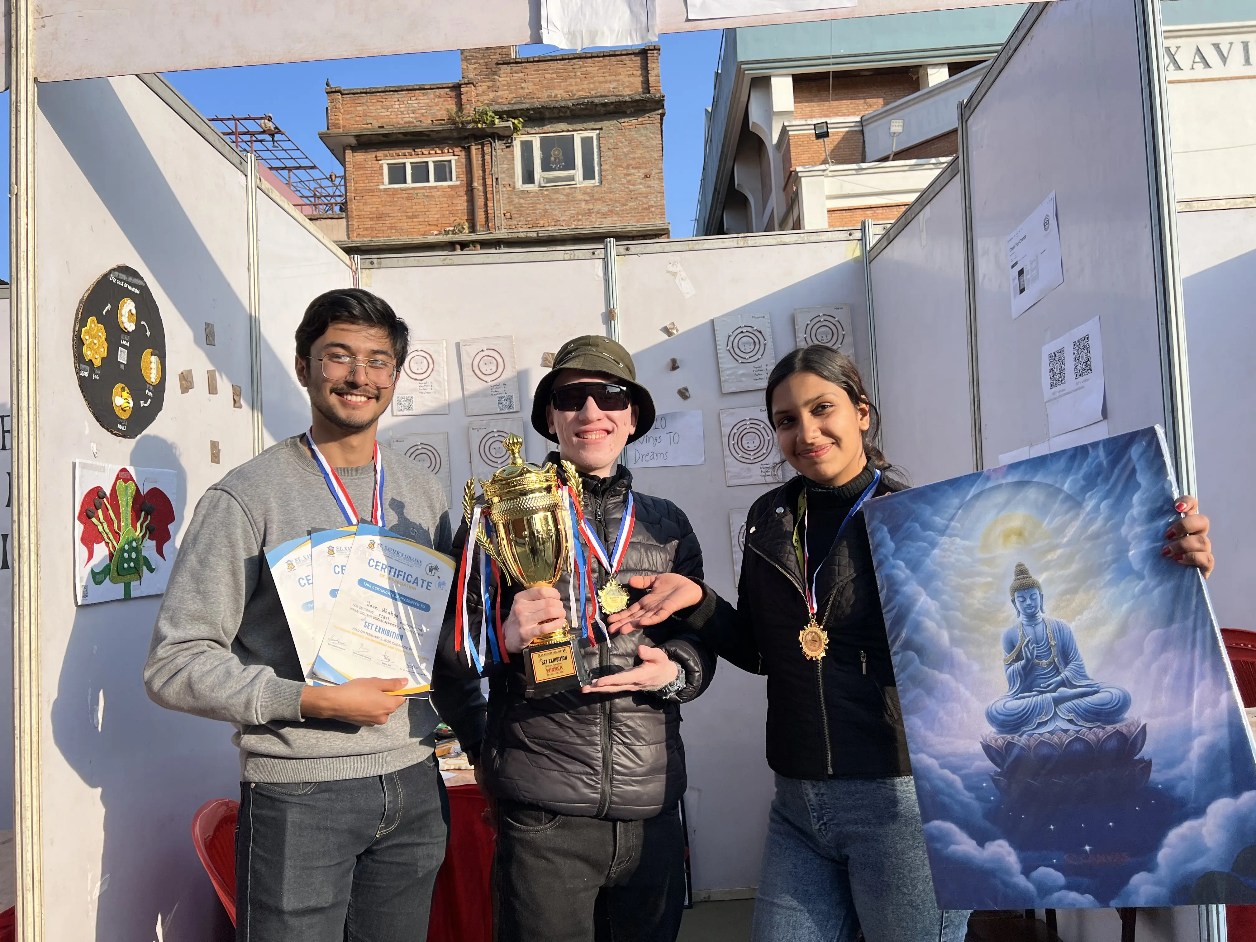 All 3 Project members Karmendra Shrestha is holding the certificate, Joon Shakya is lifting the trophy and Sanskriti Pokharel is lifting the canvas of Gautam Buddha as a winning prizes of SET exhibition.