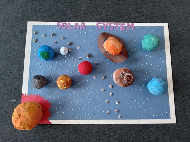 A picture of 3D Solar System board with planets.