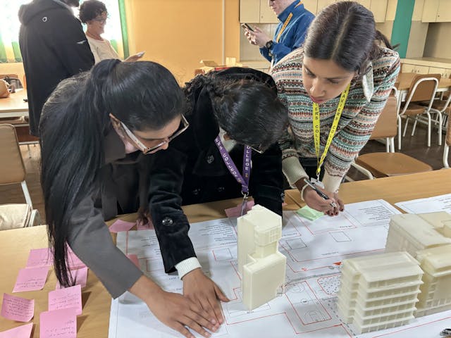 Samjhana Rijal and Sabitri Poudel are reading the braille index of the 3D maqueta of St. Xavier's College. On right, project member Sanskriti Pokharel is observed taking note of the feedback given by them. In the background Valeria Mullar is also observing them quietly.