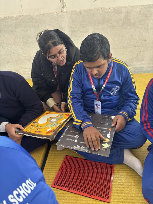 A male child is perceiving the 3D model of plant cell and Khushi Subedi one of the project members is giving explanation about it.