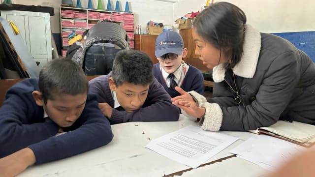 Project member Romee Jijicha is explaining about amoeba and her 3D model to the students and the students are listening carefully to her.