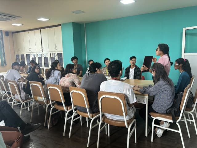 Facilitator Sabitri Poudel is holding the Braille slate and explaining about its concept to the project members.
