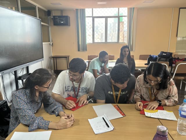 On left, Supporting Facilitator Asmita Sainju is guiding Ashwini Kyasta to write Braille and on right, Smriti Pant is looking at Braille chart to write on braille and Soyas Shrestha is observing.