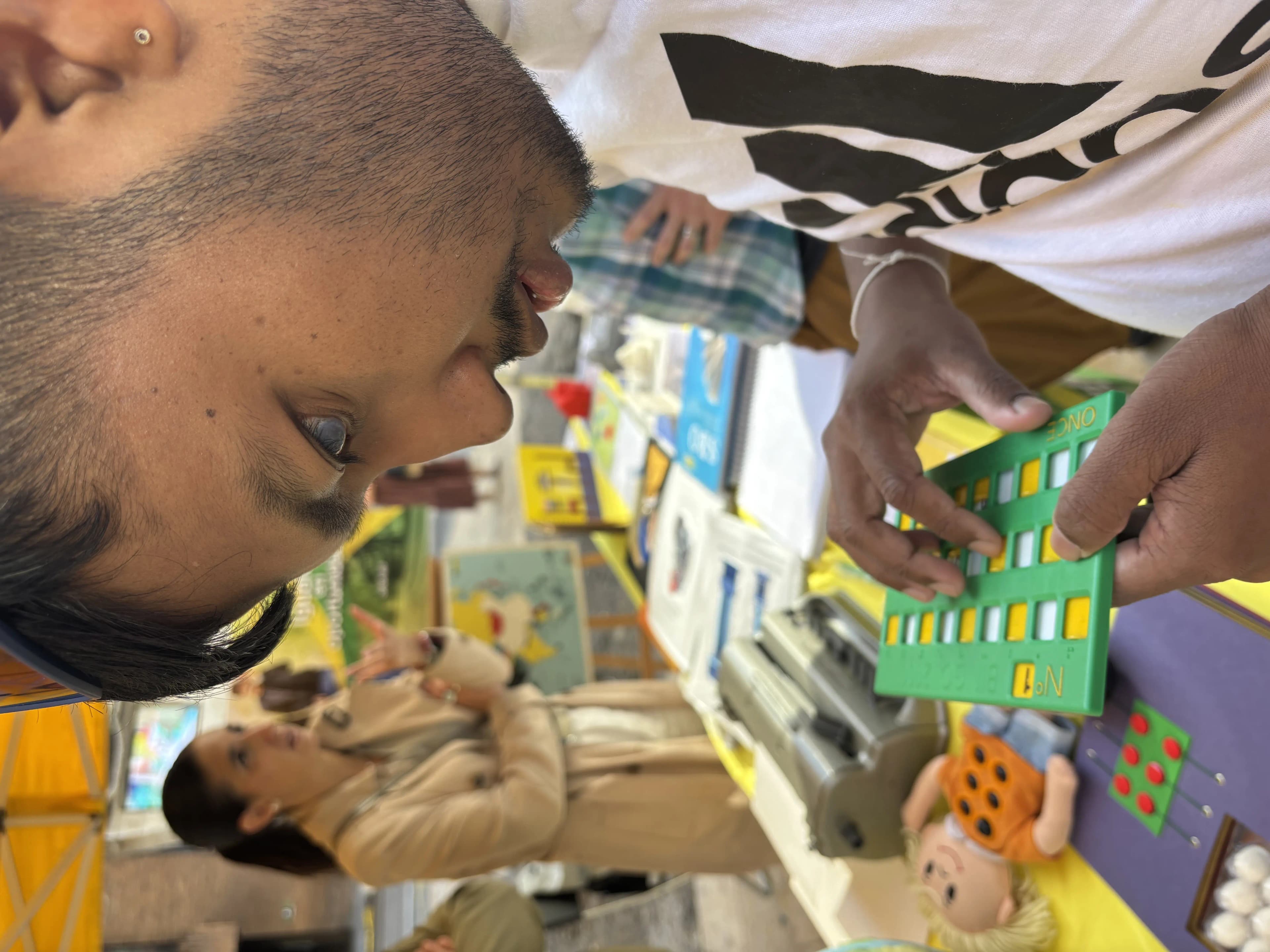 Our Founder Abhishek Shahi touching the accessible board game 'BINGO' specially made for individual with visual disabilities.