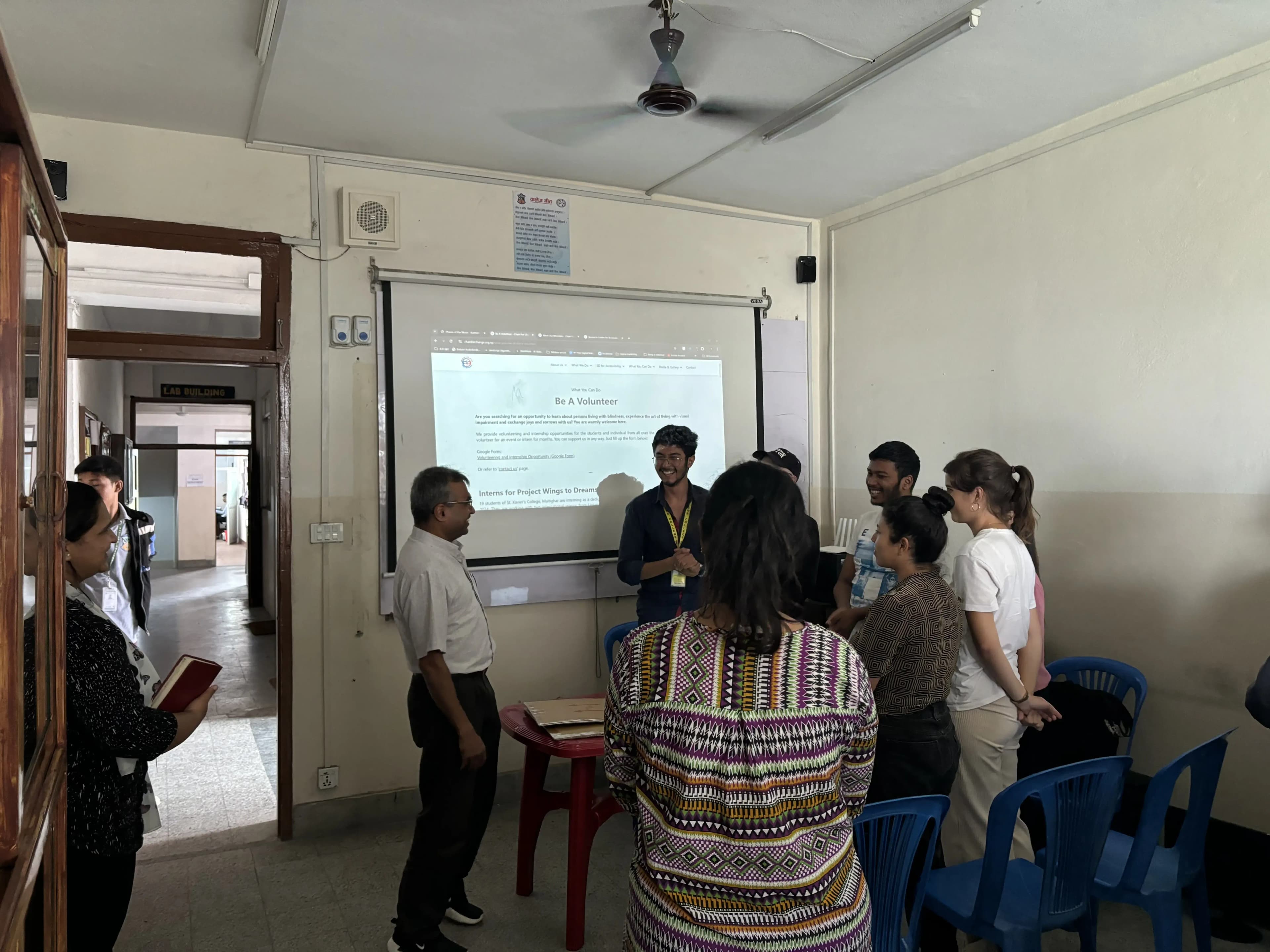 Fr. Jiju Varghese, S.J paying a visit during the event. In the background our Founder, officers, international interns and Anupa ma'am – staff of OICP of St. Xavier's College, Maitighar is also observed.