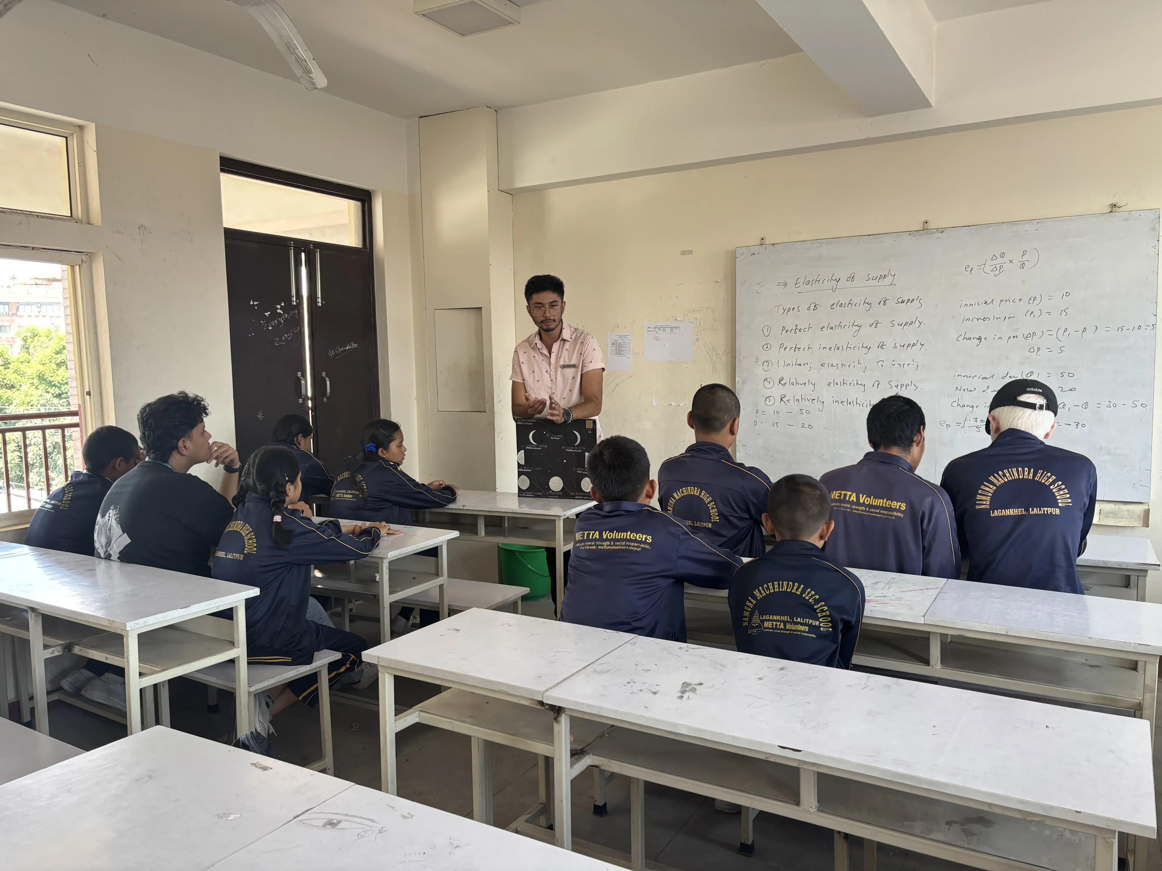 One of our Officers Mr. Karmendra Shrestha is holding the 3D model and explaining about 'Phases of the Moon'. In front of him, 9 students with visual disabilities and a officer Mr. Sangam Khadka is observed listening.