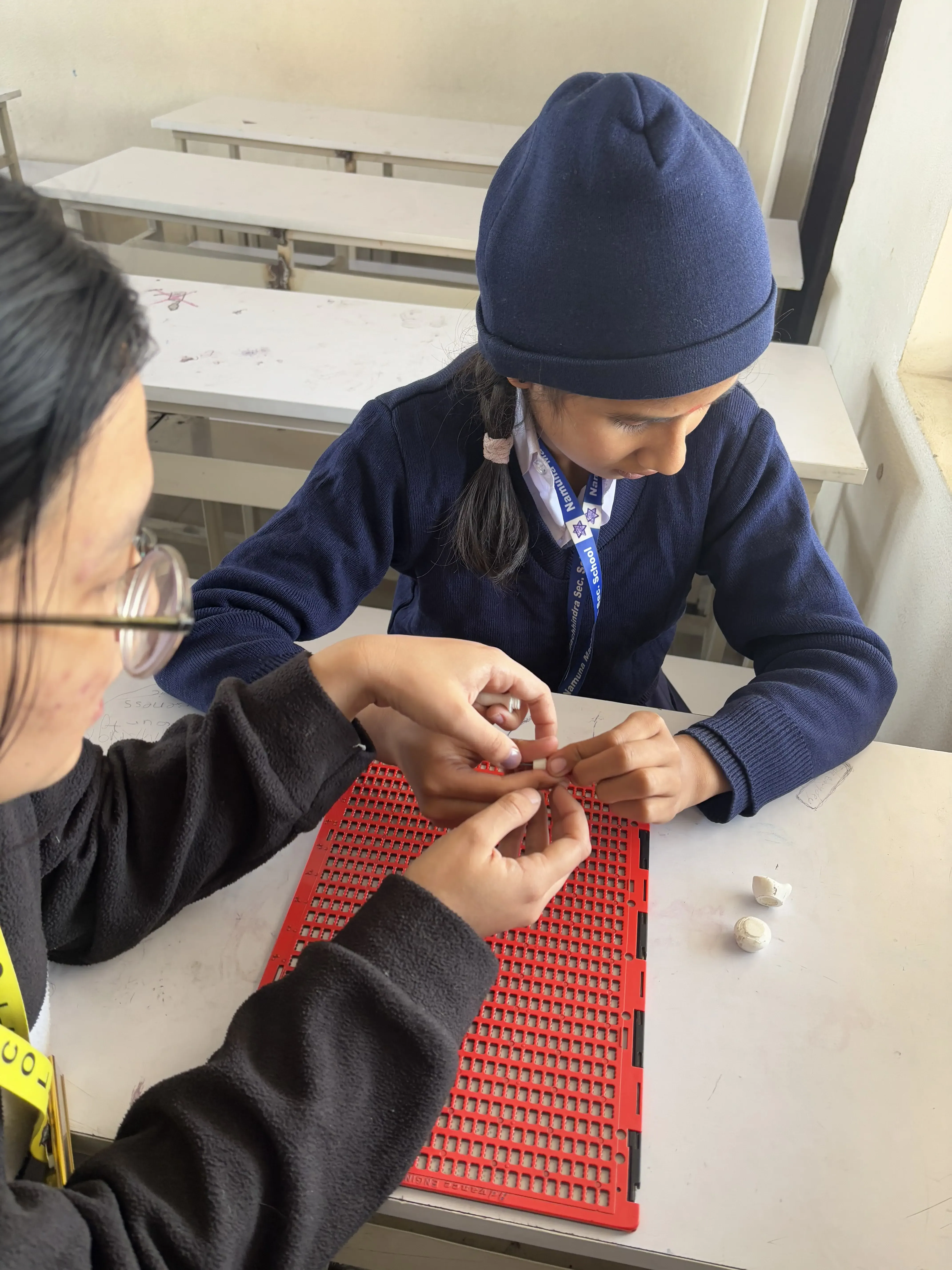 A picture of our project member Sanskriti Ghimire is teaching one of the female students with visual disability to use the 3D customizable stylus.