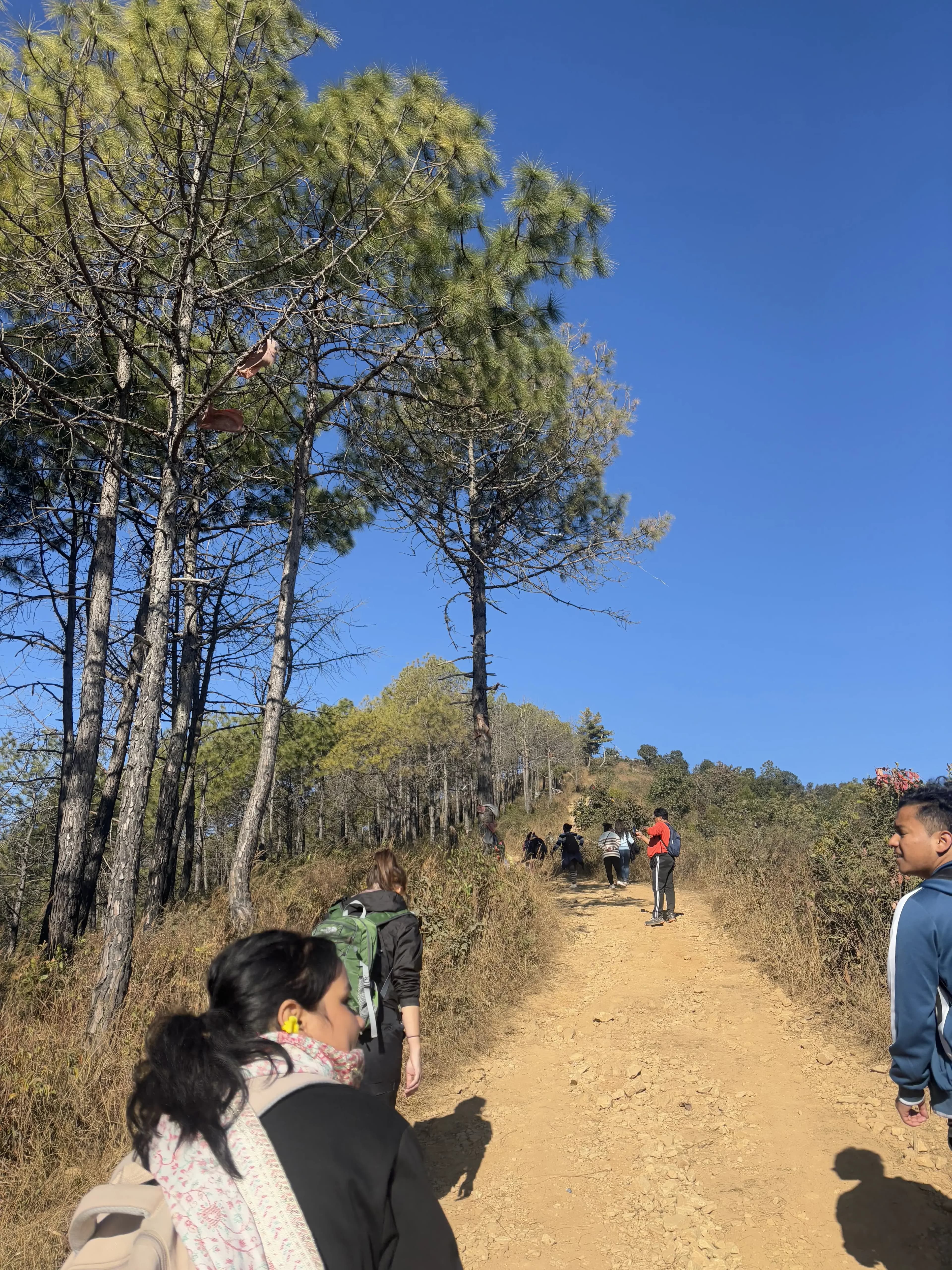 A picture of 3 of our project members hiking in the route. In the background, there are fellow hikers and a beautiful view.