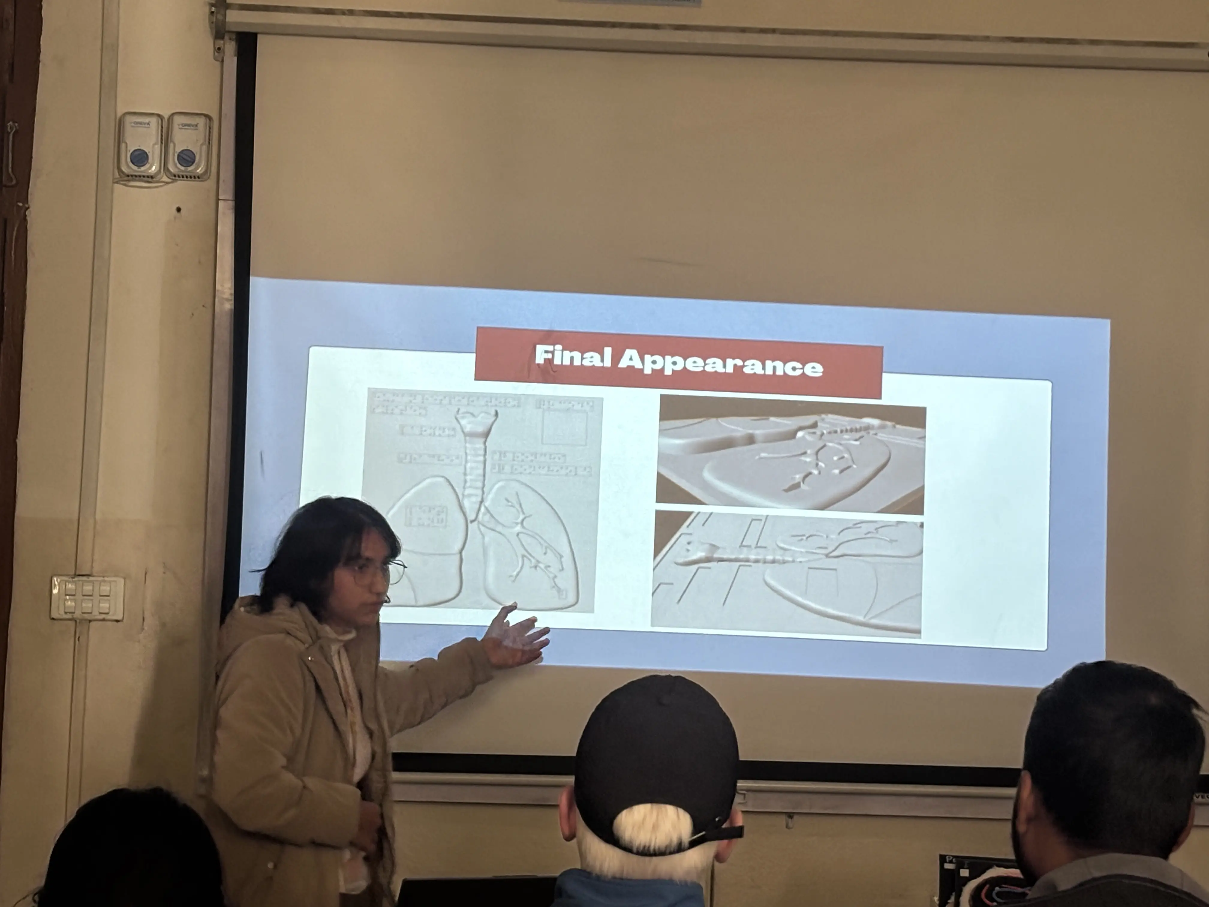 One of the project members, Smriti Pant is presenting about her 3d model. In the background, a diagram of her 3D model is being projected in a slide.