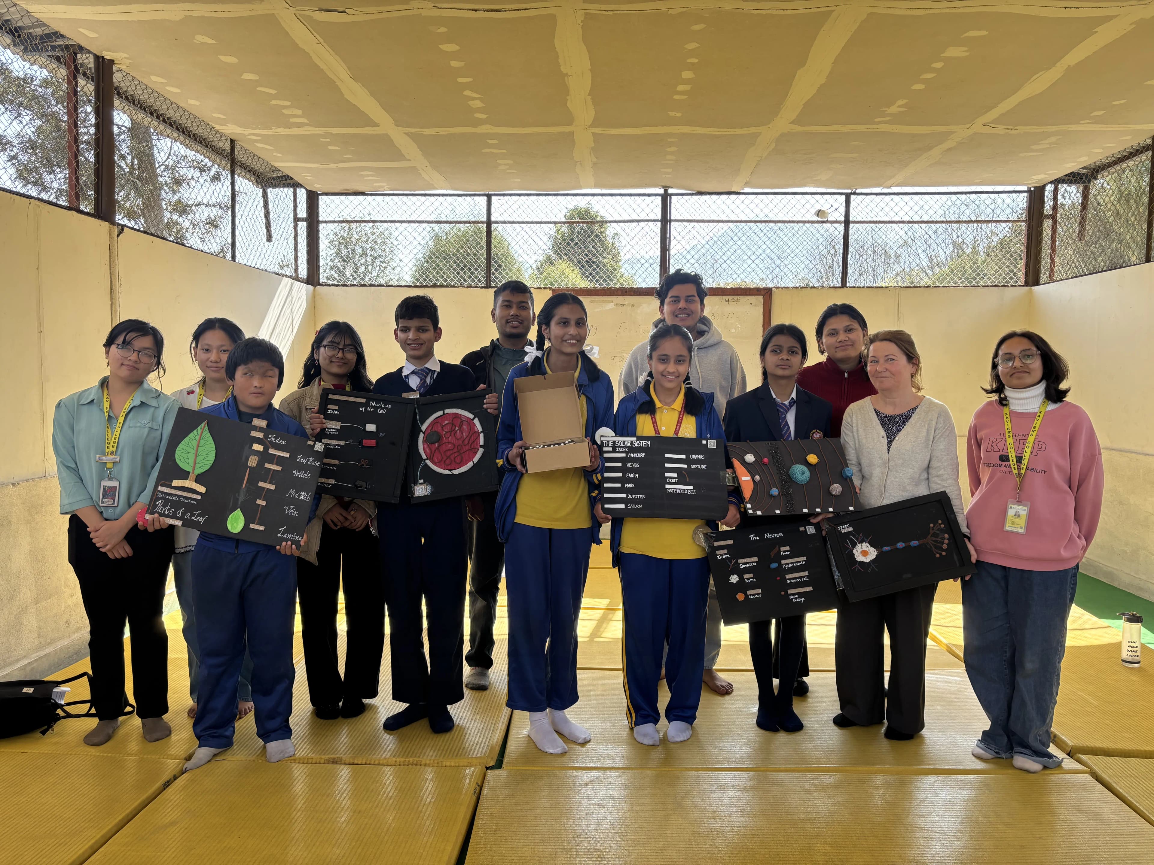 A group picture of 13 individuals consisting of 5 students with visual disabilities, project members, exchange staff, officers and executives of CFC.
