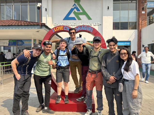 A group picture of 8 individuals including Mr. Alfonso Xosé González Cabarcos and his 4 Spanish students along with CFC members. In the background, there is a photo stand where it is written 'I love Chandragiri'.