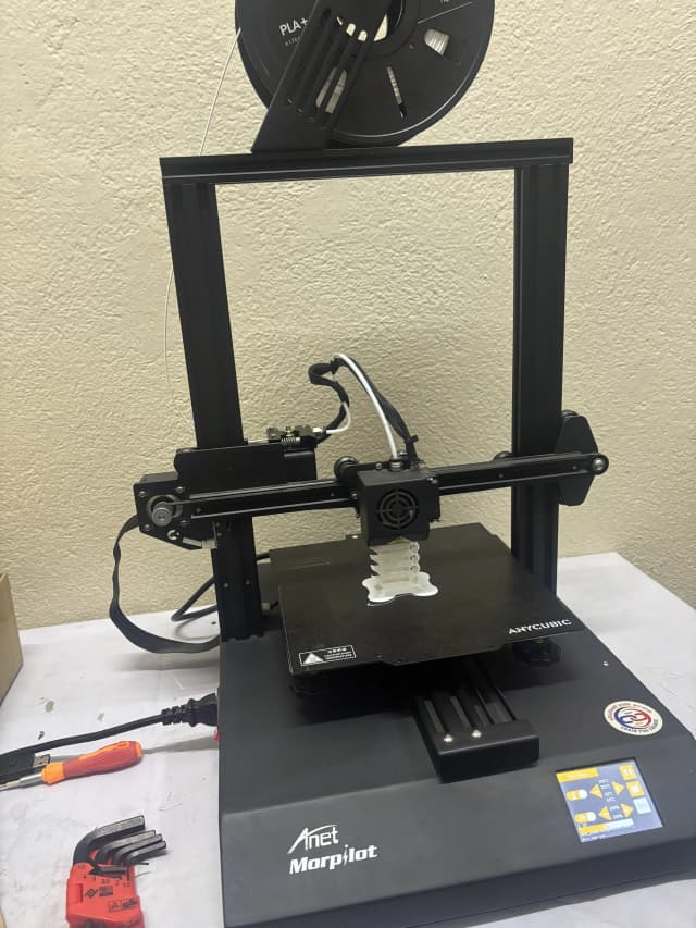 The FDM 3D printer is printing the temperature tower using its filament.