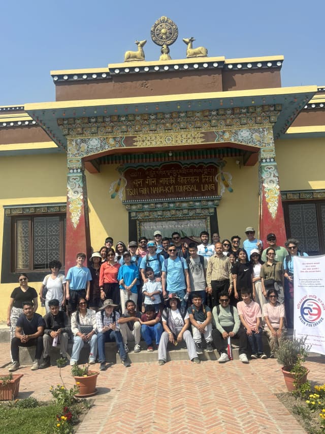 A group picture of around 42 individuals including project members, teachers and students with visual disabilities from Lab Schools, Spanish volunteers and facilitators, representative from Access Nepal and members of CFC. On the right, there is the banner of CFC and on background the entrance to the stupa is observed.