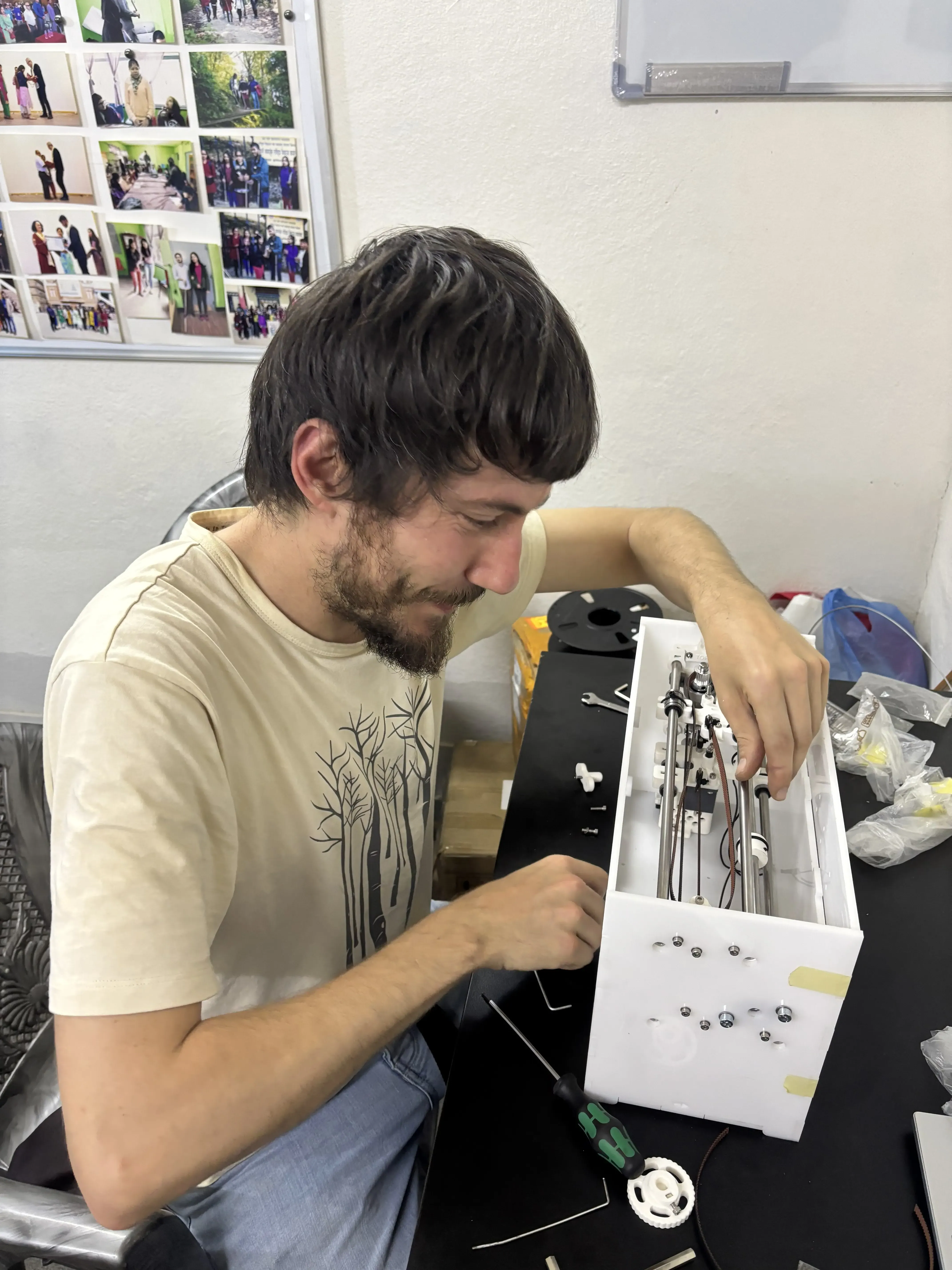 Mr. Miquel Cañada is building a Nepal's 1st DIY braille printer. In the background, some tools and spare parts are placed in the table.