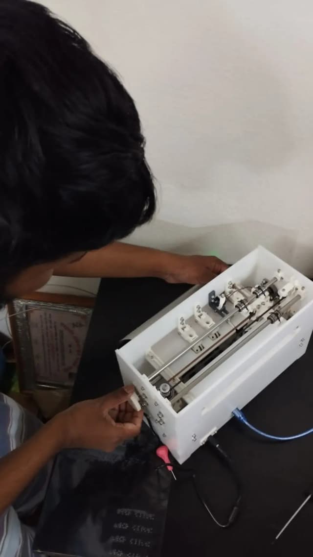Our Founder, Mr. Abhishek Shahi is placing a paper in the braille printer to print.