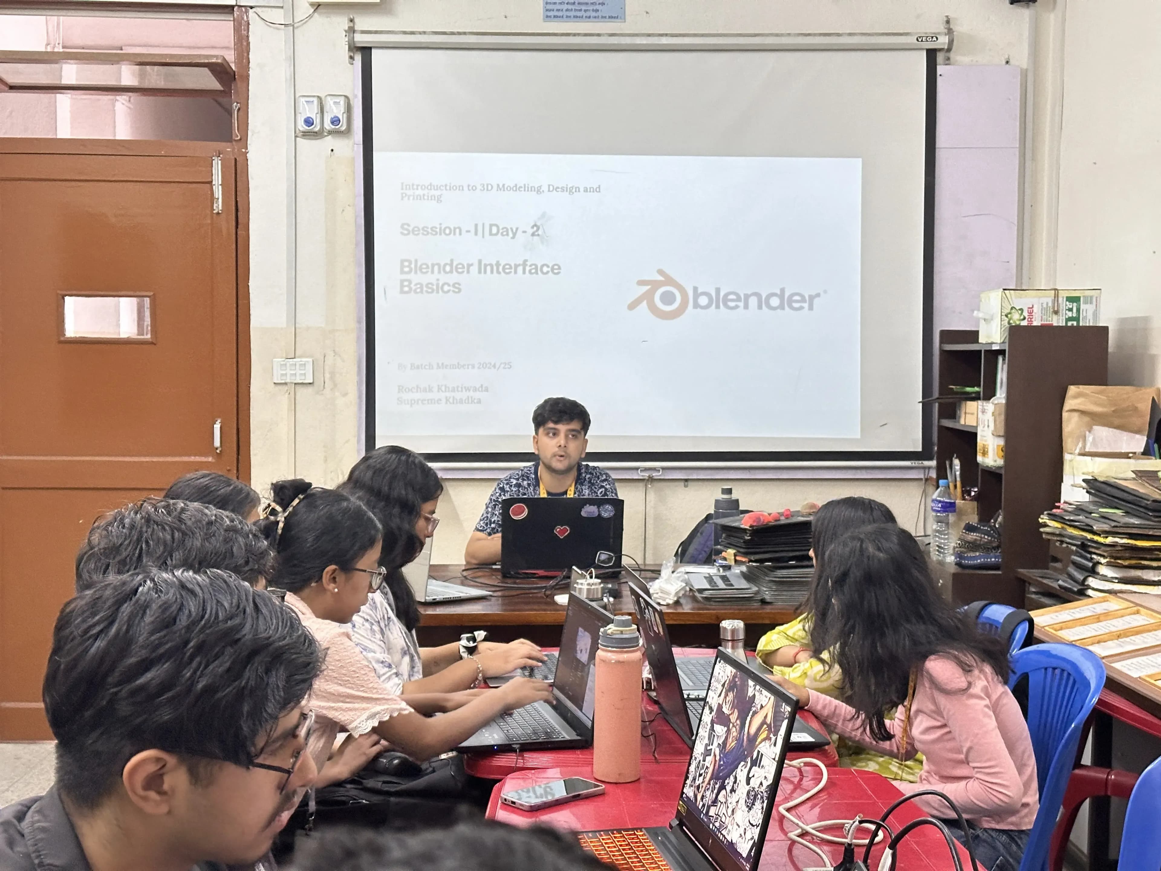 One of the computer departmental members, Mr. Rochak Khatiwoda is facilitating the event. "Blender Basic Interface" is being projected. The 3D Design & Printing Officer, Ms. Garima Shakya is supporting the participating new members.