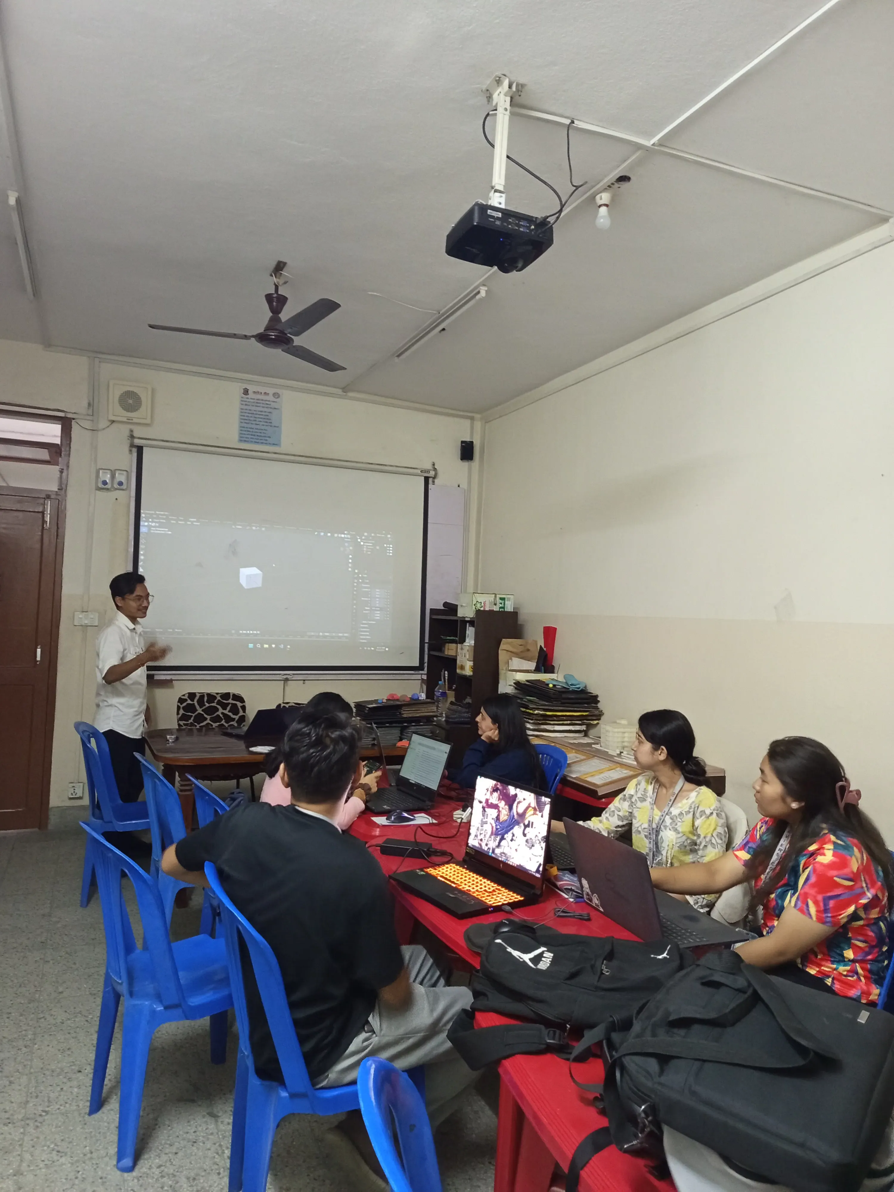 One of the members of Computer Department (2024/25) Mr. Rayan Karki is facilitating a session and a cuboid is projected in the background.
