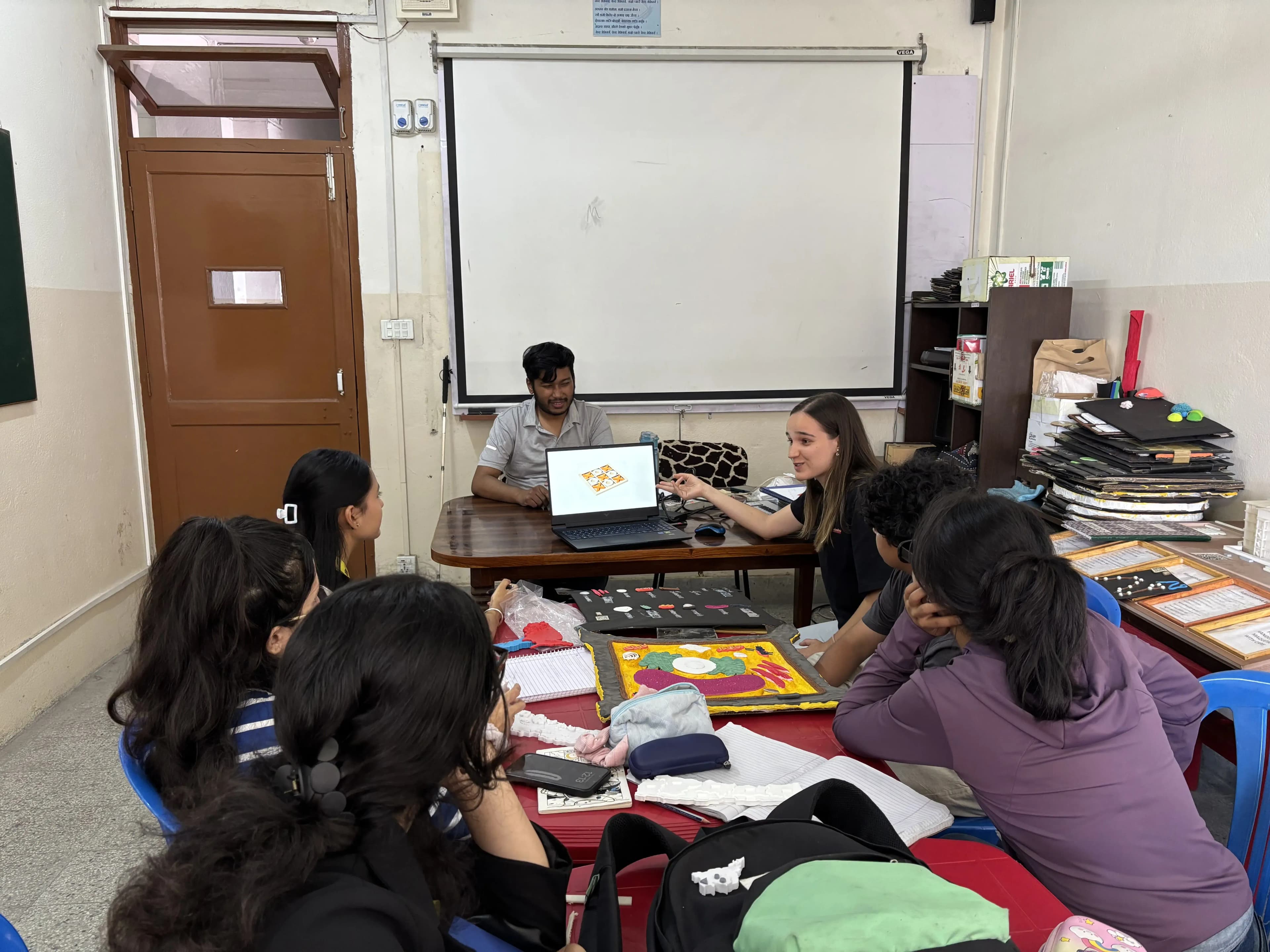 Intern Design Instructor (2025/26), Ms. Ines is sharing some ideas for inclusive games to the participants of the workshop. On the table, a 3D model of plant cell is also observed.