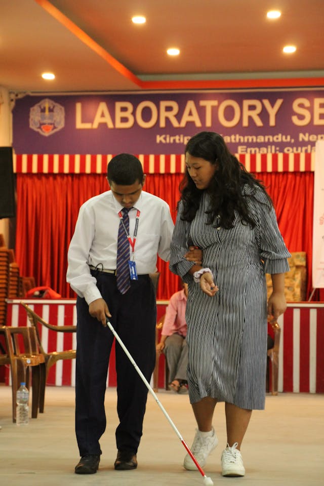 Anjali Maharjan – one of the guides to participants with visual disabilities is explaining and supporting her pair to use his white cane.