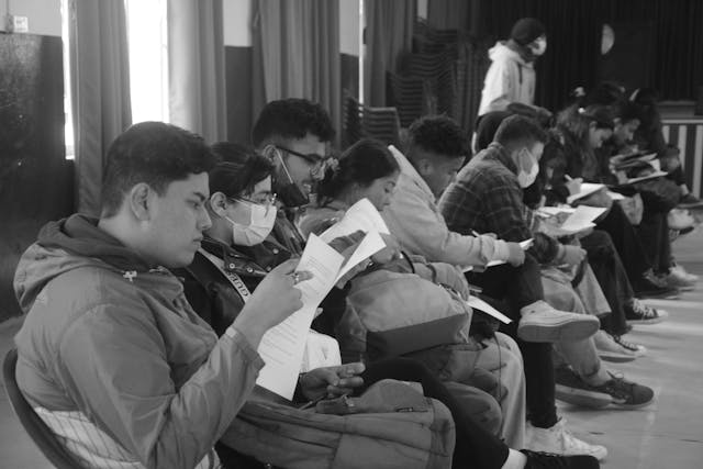 A black & white picture of all the participants filling up the form during the 1st day of Guiding Techniques & Mobility Skills Training - 2023.