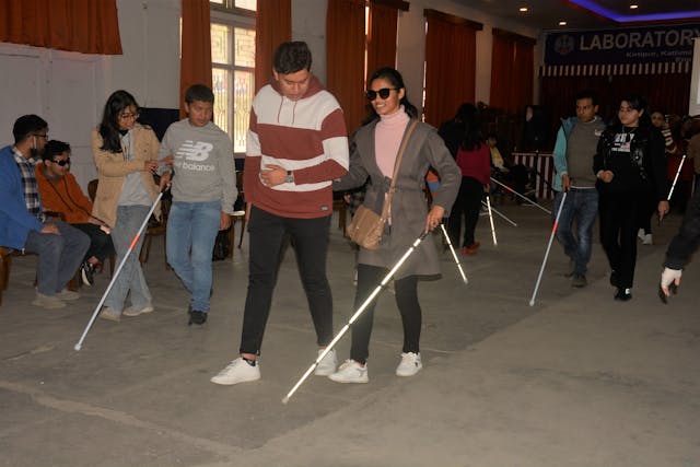 Guides and their pair with visual disabilities are practicing proper guiding techniques and mobility skills using their white cane.