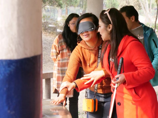 Cofounder & Treasurer of Chain For Change, Sanjiya Shrestha guiding blindfolded guide Sarah Maharjan during the training.